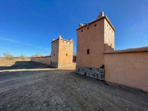 Nkob的住宿－Magical Berber Camp，沙漠上一座建筑物顶部的两座塔楼