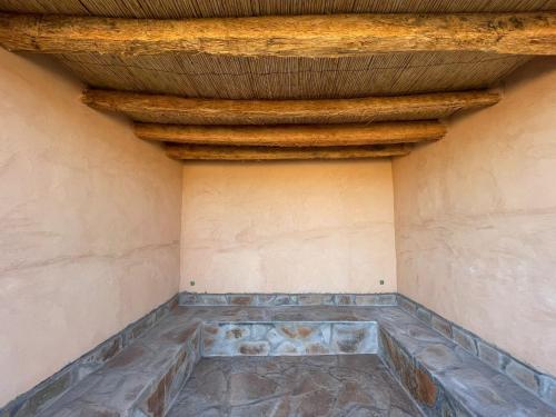 Nkob的住宿－Magical Berber Camp，一间设有石材地板和木制天花板的客房