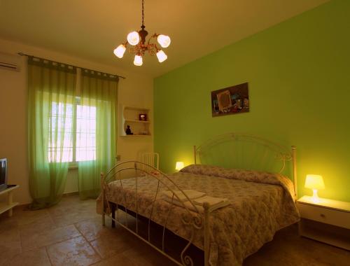 マリーナ・ディ・マンカヴェルサにあるCountry Salenthouseのベッドルーム1室(緑の壁のベッド1台、シャンデリア付)