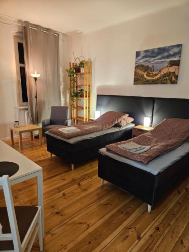 ein Zimmer mit 3 Betten und einem Stuhl darin in der Unterkunft Kamienica Nowodworska 30 in Bydgoszcz