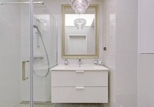 Baño blanco con lavabo y espejo en Exclusive Apartment Motlawa River Oldtown, en Gdansk