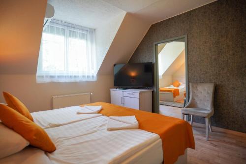 una camera d'albergo con letto e specchio di Szalajka Fogadó és Étterem a Szilvásvárad