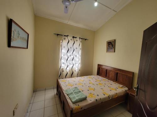 um pequeno quarto com uma cama e uma janela em Nicely Furnished Comfortable Holiday Apartment Home at Yarambamba Estate em Yundum