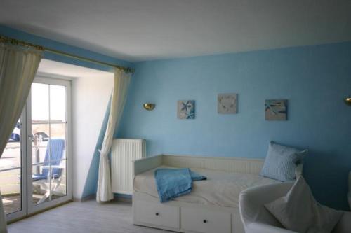 a bedroom with blue walls and a bed and a window at Seeschloss 30 in Dahme