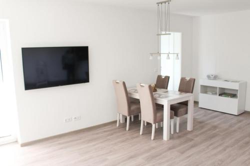 a dining room with a table and chairs and a tv at Zur Strandwiese W2 in Dahme