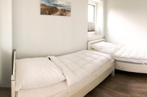 a bedroom with two beds and a window at Zur Strandwiese W4 in Dahme