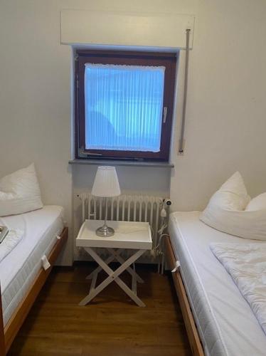 a room with two beds and a table with a window at Feriengarten Dahme W 20 in Dahme