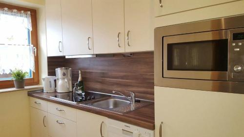 uma cozinha com um lavatório e um micro-ondas em Jacobihof Haus 15 Wohnung 03 em Dahme