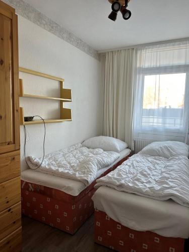 two twin beds in a room with a window at Strandhotel Wohnung 2 in Dahme