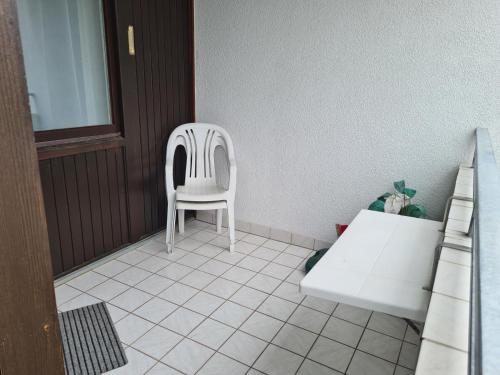 una sedia bianca seduta in una stanza di Strandhotel Wohnung 2 a Dahme