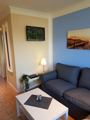 una sala de estar con un sofá y una mesa en Feriengarten Dahme W 14, en Dahme