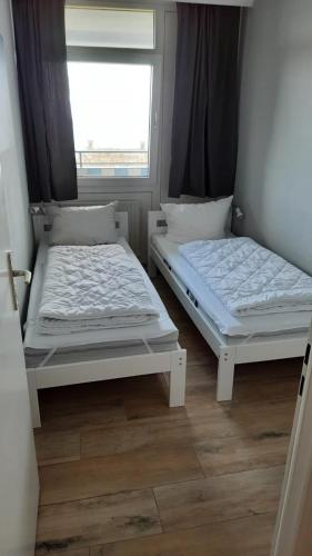 two beds in a room with a window at Strandhotel Wohnung 31 in Dahme