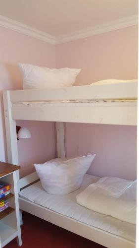 a white bunk bed with some pillows on it at Feriengarten Dahme W 9 in Dahme