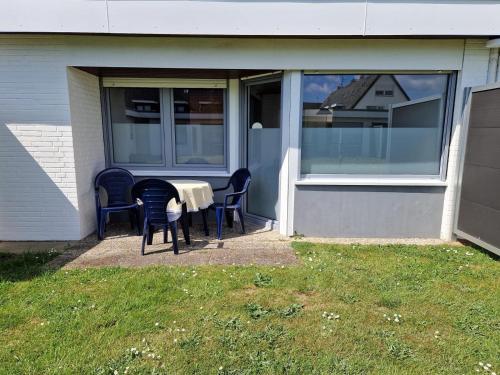 a patio with chairs and a table in front of a house at Feriengarten Dahme W 5 in Dahme