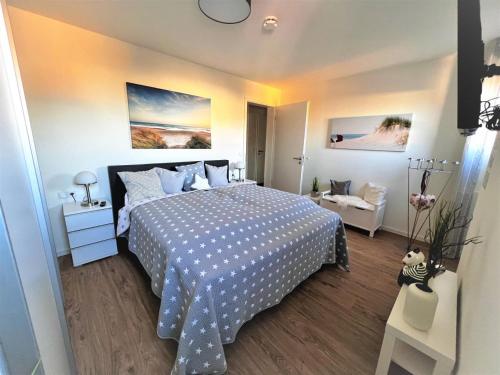 a bedroom with a bed with a blue and white bedspread at Dahmer Strand 18 Muschelhus in Dahme