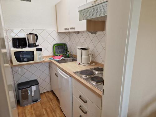 a small kitchen with a stove and a microwave at Feriengarten Dahme W 3 in Dahme