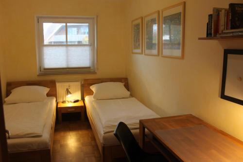 a room with two beds and a table and a window at Jacobihof Haus 9 Wohnung 02 in Dahme