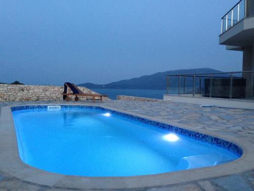 a large blue swimming pool next to a building at Kefalonia Horizon Villas in Ayia Evfimia