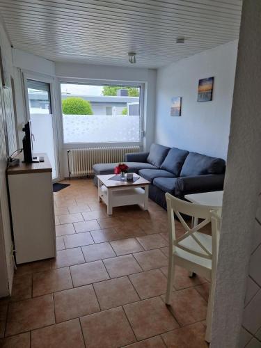 a living room with a blue couch and a table at Feriengarten Dahme W 7 in Dahme