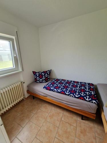 a small bed in a room with a window at Feriengarten Dahme W 7 in Dahme