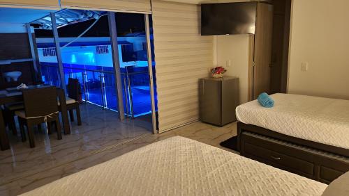a bedroom with a room with a bed and a table at PISCINA SARITA CLUB BOUTIQUE in Girardot