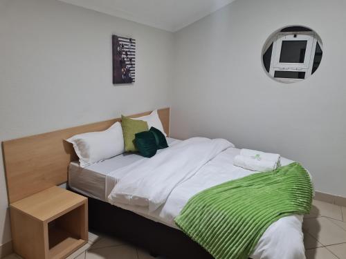 um quarto com uma cama com um cobertor verde em Pastello guest house em Maputo