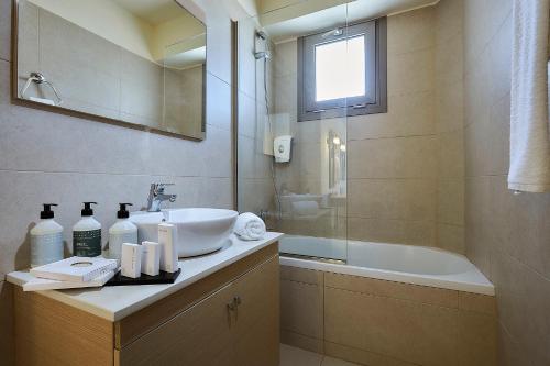 uma casa de banho com um lavatório e uma banheira em Sissi Bay Resort em Sissi
