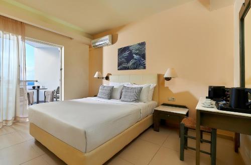 a bedroom with a bed and a desk with a television at Sissi Bay Resort in Sissi