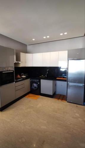 a kitchen with white cabinets and stainless steel appliances at Dar el yousser in Casablanca
