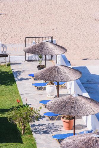 a row of tables with umbrellas on the beach at Santa Rosa Hotel & Beach in Alexandroupoli