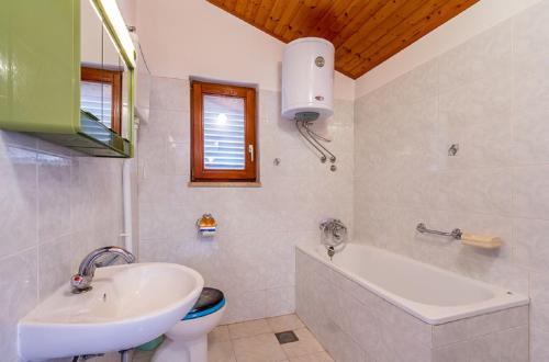 La salle de bains est pourvue d'un lavabo, d'une baignoire et de toilettes. dans l'établissement House Cador, à Vinkuran