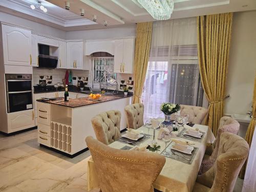a kitchen with a table and chairs and a kitchen with a counter at Serene villaz in Kampala