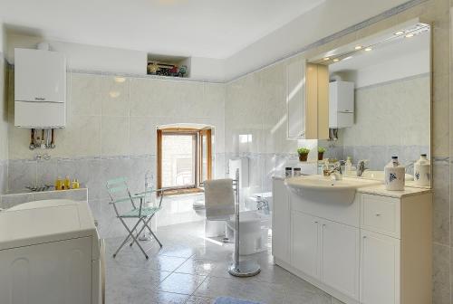 a white bathroom with a sink and a tub at Villa Orbanici in Orbanići