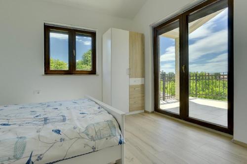 a bedroom with a bed and a large window at Villa Amorea in Šegotići
