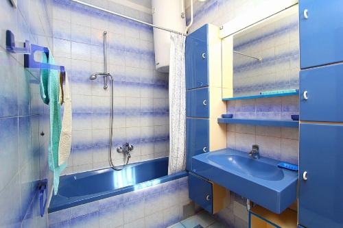 uma casa de banho azul com um lavatório e um chuveiro em Apartment Jovanka em Medulin