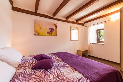 a bedroom with a purple bed with two pillows at Villa Zvane in Žminj