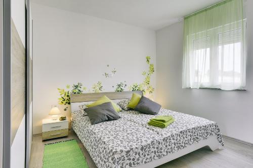 ein Schlafzimmer mit einem Bett in einem weißen Zimmer in der Unterkunft Villa Kata in Rebići