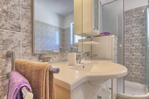 La salle de bains blanche est pourvue d'un lavabo et d'un miroir. dans l'établissement Casa Nina & Tea, à Valtura