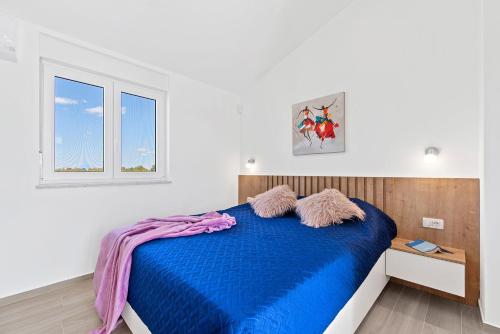 ein Schlafzimmer mit einem blauen Bett und einem Fenster in der Unterkunft Villa mit Privatpool, Ping-Pong, BBQ in Štokovci