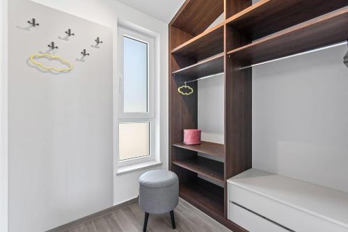 ein Schlafzimmer mit einem Bett, einem Fenster und einem Stuhl in der Unterkunft Villa mit Privatpool, Ping-Pong, BBQ in Štokovci