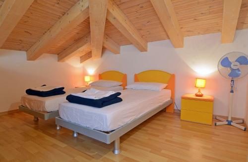two beds in a bedroom with a wooden ceiling at Villa Blue II in Banjole