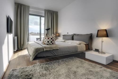 a bedroom with a large bed and a large window at Apartment City Business in Pula