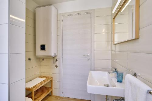 uma casa de banho branca com um lavatório e um chuveiro em Villa Chiara em Premantura