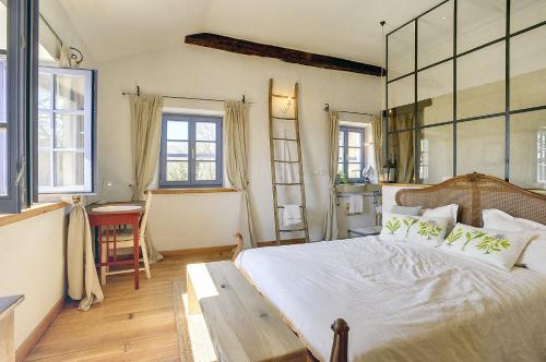 a bedroom with a large bed and two windows at Villa Torrecorta in Grožnjan