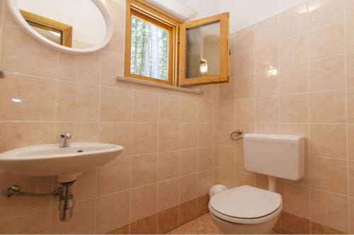 ein Badezimmer mit einem WC, einem Waschbecken und einem Spiegel in der Unterkunft Villa Stella in Kloštar