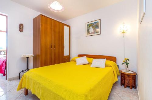 a bedroom with a yellow bed in a room at Fernando in Peroj