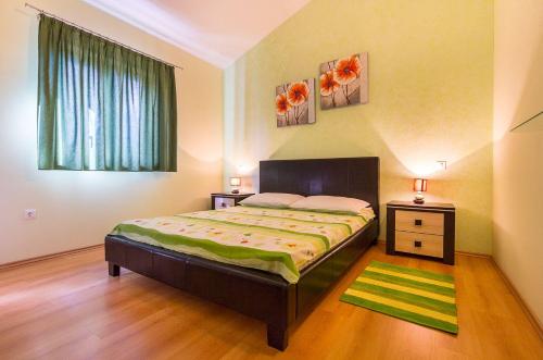 1 dormitorio con 1 cama, 2 mesas y una ventana en Villa Prima, en Jurići