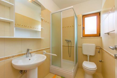 uma casa de banho com um lavatório, um WC e um chuveiro em Villa Prima em Jurići