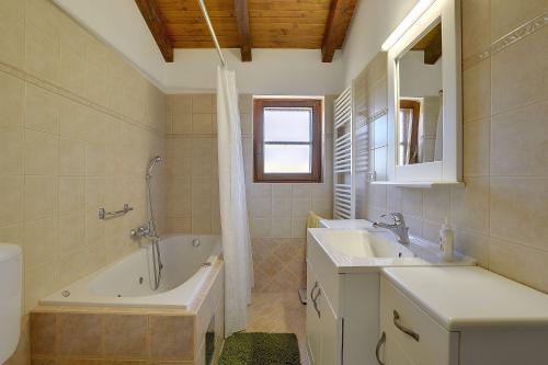 y baño con bañera, lavabo y bañera tubermottermott. en Villa Angelo & Marija, en Jehnići
