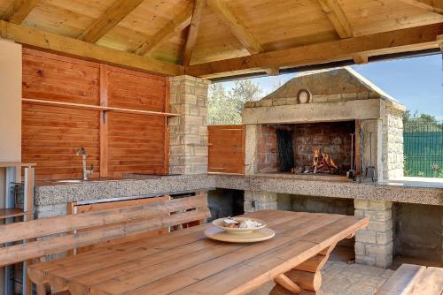 an outdoor kitchen with a wooden table and an oven at Villa Jela in Medulin
